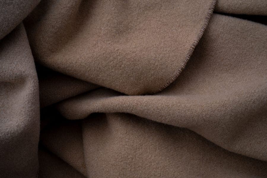 A quilted fleece liner fitted into the base pan of a multi-level cage