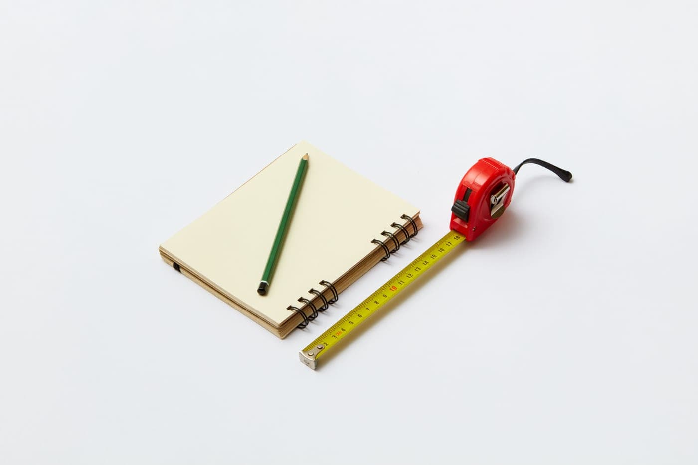 A tape measure, printed care guidance and a sample of powder-coated wire mesh on a desk