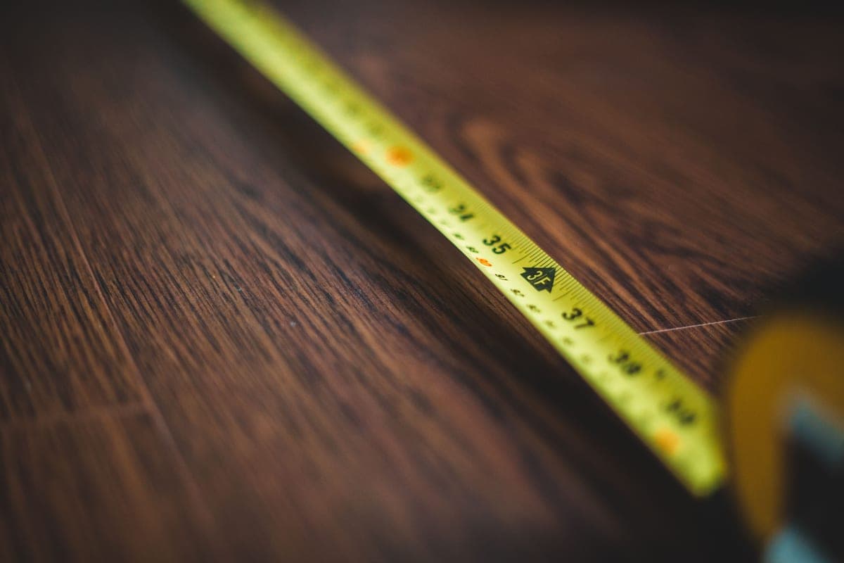 A measuring tape stretched across the floor of a large rabbit enclosure